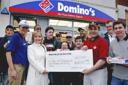 Domino's staff present cheque to young athletes