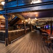 The venue boasts a vintage, old-timey interior, with soft lighting and       majestic copper kegs, giving the place an 