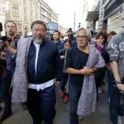 Artists Ai Weiwei (left) and Anish Kapoor are joined by members of the media and public as they walk down Piccadilly