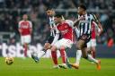 Arsenal's Gabriel Martinelli (centre) passes the ball away from Newcastle United's Bruno Guimaraes (left) and Jacob Murphy. Image: PA