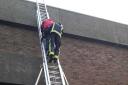 The unfortunate worker being helped down the ladder after getting stuck on the roof of his office building. Photo: London Fire Brigade