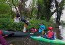 Volunteers fro Meridian Canoe Club, Andy Garlick's home club, load rubbish collected in waste bags into an open canoe.