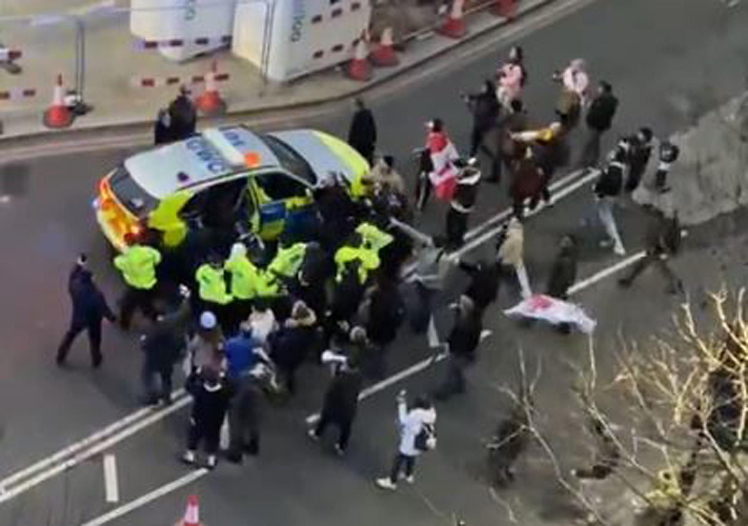 Video grab image courtesy of Conor Noon of clashes between police and protesters in Westminster as officers use a police vehicle to escort Labour leader Sir Keir Starmer to safety. 