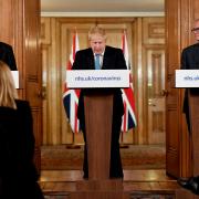 Chief Medical Officer Professor Chris Whitty (left) and Chief Scientific Adviser Patrick Vallance (right) watch as Prime Minister Boris Johnson at the news conference inside 10 Downing Street, London