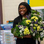 Member of staff at SHINE Merton with donated flowers