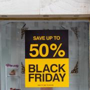 Poster outside storefront, luring people to spend in Black Friday discounts.