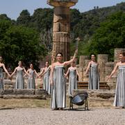 Actress Mary Mina, playing a priestess, holds a torch with the flame during the final dress rehearsal of the flame lighting ceremony for the Paris Olympics, at the Ancient Olympia site in Greece (Thanassis Stavrakis/AP)