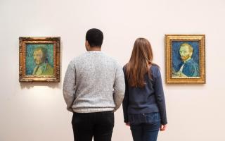 Courtauld staff member Aaron Stennett and Amy Graves view two of Vincent Van Gogh's self-portraits, both titled 'Self-Portrait' are hung side-by-side at the Courtauld Gallery in London (PA)